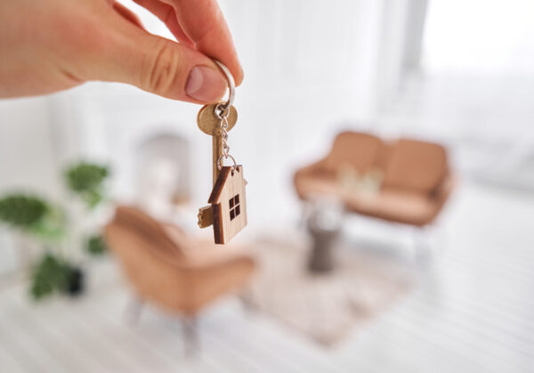 Men,Hand,Holding,Key,With,House,Shaped,Keychain.,Modern,Light